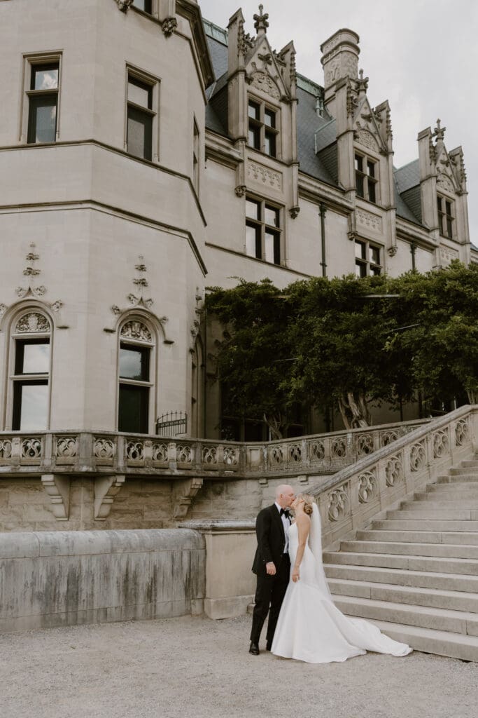 bride and groom share kiss on biltmore estate terrace